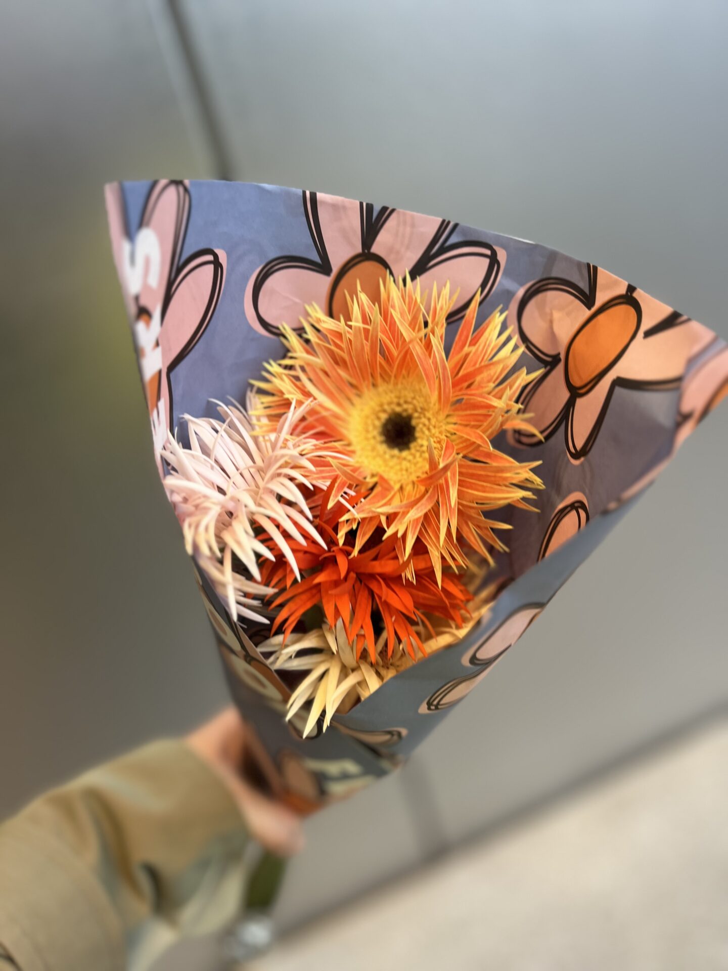 ALL GOOD FLOWERS 虎ノ門ヒルズ オレンジとピンクのスパイダー咲きガーベラと柄の包装紙
