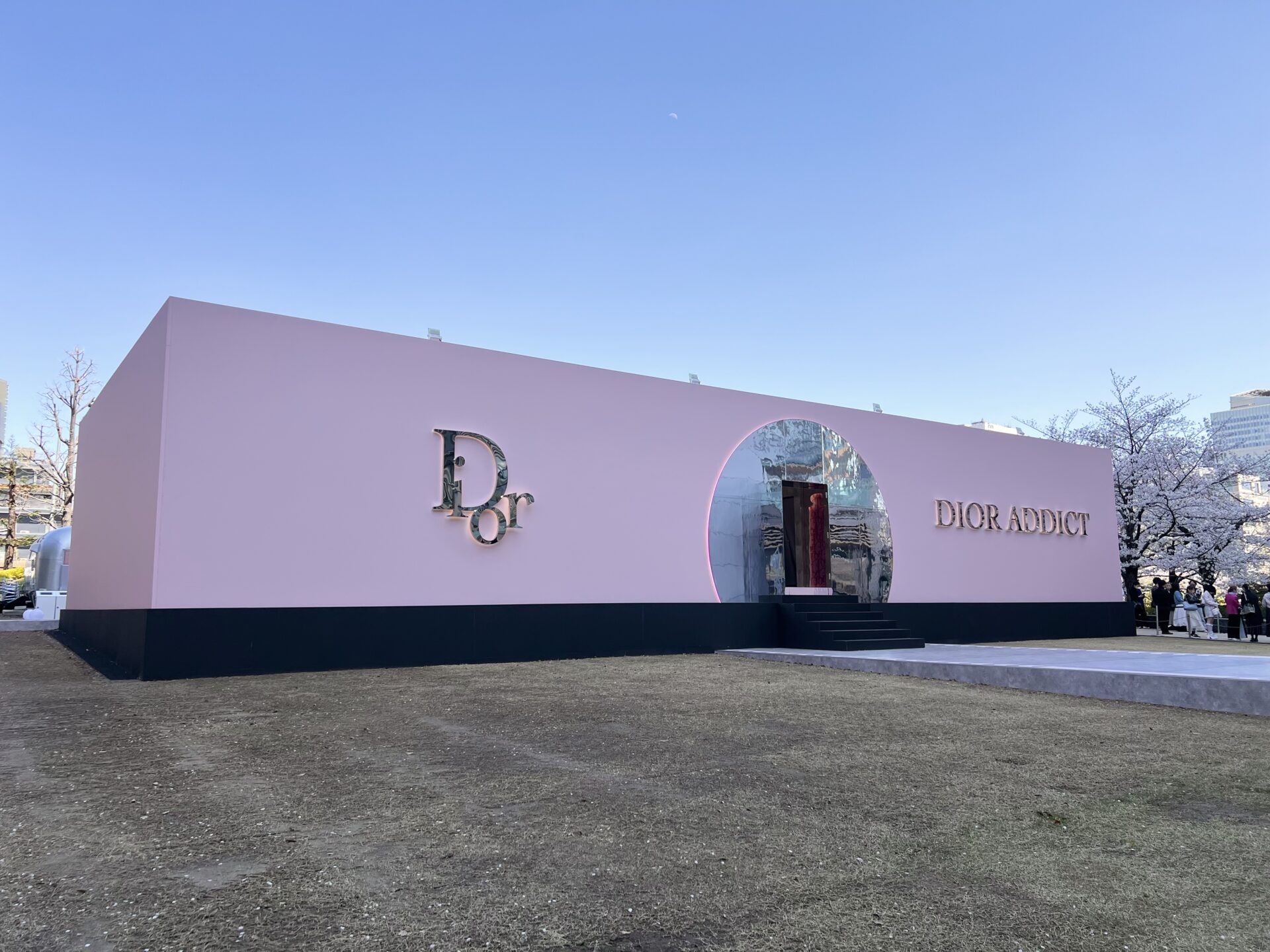 桜に囲まれたピンクの箱型パビリオン「DIOR ADDICT」の外観