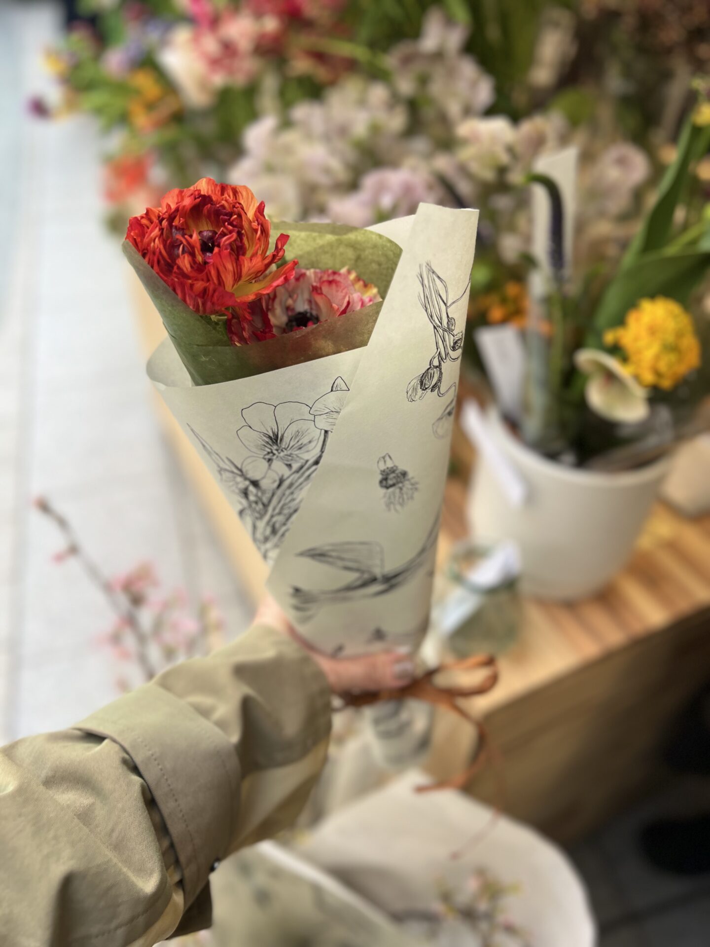 植物のイラストが描かれた紙で包まれた花束