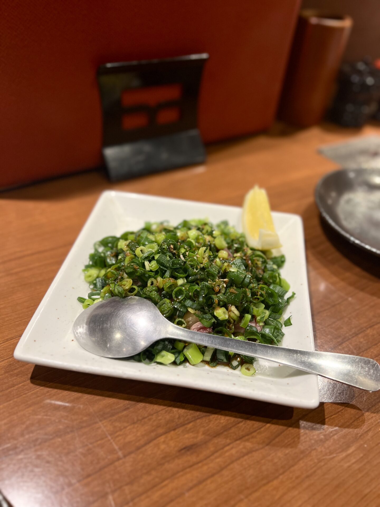 青ねぎ山盛りの鶏料理とレモン